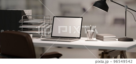 Modern office desk with laptop mockup, table lamp, office supplies and stationery 96549542