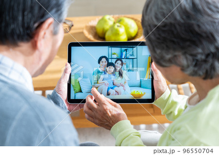 オンラインで娘夫婦と通話するシニアの夫婦 96550704