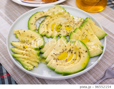 ripe avocado pulp cut into pieces sprinkled with lemon juice on a plate 96552154