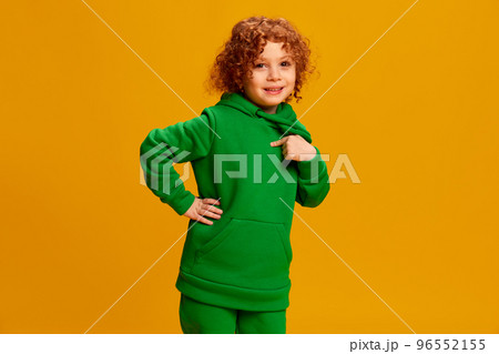 Portrait of cute little girl, child with curly red hair cheerfully posing isolated over yellow background 96552155