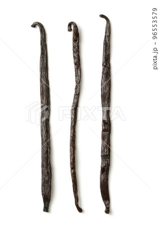 Dried Bourbon vanilla pods, vanilla beans from above. Three whole, dark brown and ripe fruits of Vanilla planifolia, a spice with distinctive flavor, used in baking. Top view, on white background. Dried Bourbon vanilla pods, vanilla beans from above. Three whole, dark brown and ripe fruits of Vanilla planifolia, a spice with distinctive flavor, used in baking. Top view, on white background. 96553579