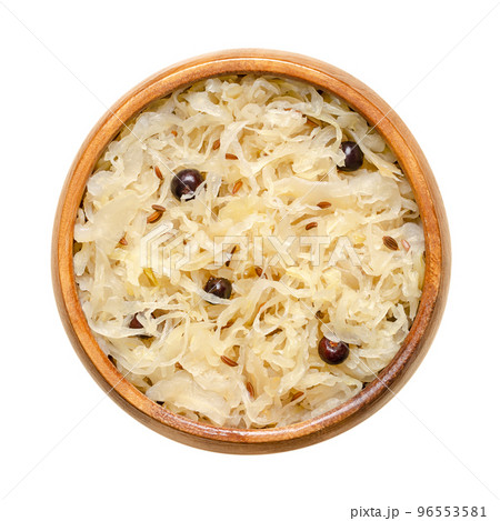 German sauerkraut, in a wooden bowl. Cut raw cabbage, fermented by lactic acid bacteria. In Austria and Germany traditionally a warm served side dish, flavored with juniper berries and caraway seeds. 96553581