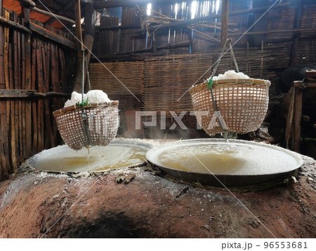 Rock salt in the basket hung above the boiling pan with white smoke and steam, Clay oven in the house, Production ancient salt at  Bo Kluea District, Nan Province , Thailand 96553681