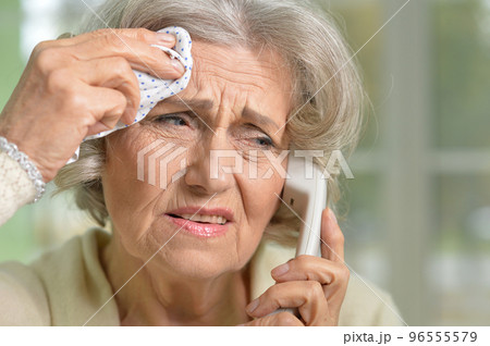 Elderly woman holding her hand to her throat. Disease 96555579