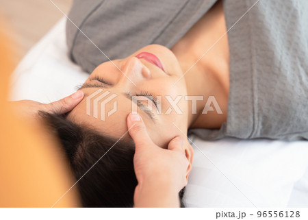 Young woman enjoying face massage in spa salon Young woman enjoying face massage in spa salon 96556128