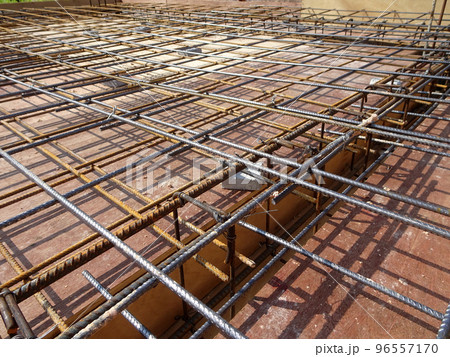 MELAKA, MALAYSIA -JULY 2, 2022: Steel reinforcement bars are arranged according to the structural engineer's design. The steels are tied together using a small steel wire. 96557170