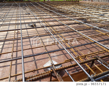 MELAKA, MALAYSIA -JULY 2, 2022: Steel reinforcement bars are arranged according to the structural engineer's design. The steels are tied together using a small steel wire. 96557171