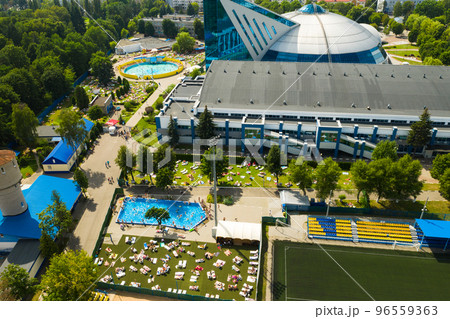 Top view of an outdoor place for people to relax where there is a swimming pool and a lot of sun beds Top view of an outdoor place for people to relax where there is a swimming pool and a lot of sun beds 96559363