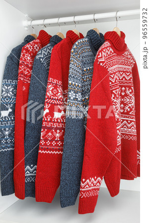 Collection of knitted Christmas turtleneck sweaters on hanger rack Collection of knitted Christmas turtleneck sweaters on hanger rack 96559732