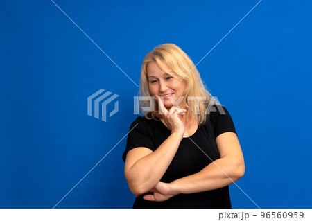 Thoughtful middle-aged businesswoman resting her chin on her hand, close up head and shoulders portrait with copy space. 96560959