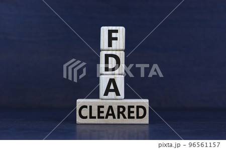 FDA, Food Drug Administration cleared symbol. Concept words 'FDA cleared' on wooden cubes and block on a beautiful grey background. Business and FDA, Food Drug Administration cleared concept. FDA, Food Drug Administration cleared symbol. Concept words 'FDA cleared' on wooden cubes and block on a beautiful grey background. Business and FDA, Food Drug Administration cleared concept. 96561157