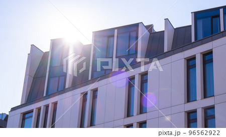 Modern office building exterior with glass facade on clear sky background. Vivid colors Transparent glass wall of office building with red pink decoration. Element of facade of modern European Modern office building exterior with glass facade on clear sky background. Vivid colors Transparent glass wall of office building with red pink decoration. Element of facade of modern European 96562922