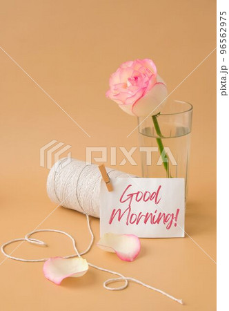 GOOD MORNING text Tender pink roses with spool of white cotton rope in heart shape on beige background. Romantic pastel pink rose flowers. Neutral earth tones. Greeting card 96562975