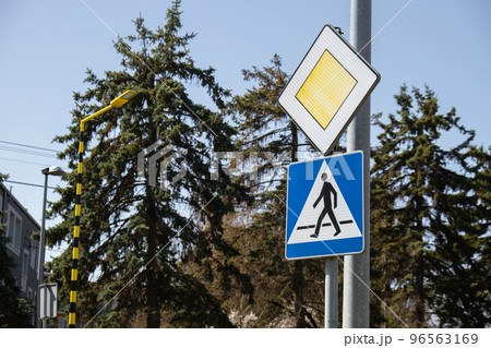 Road sign main road with pedestrian crossing sign. Speed main road daytime. Road rules International road sign Main road or Priority road against blue sky Road sign main road with pedestrian crossing sign. Speed main road daytime. Road rules International road sign Main road or Priority road against blue sky 96563169