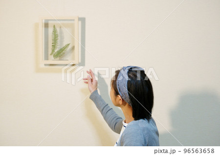 ボタニカルフレームを飾るクロスヘアバンドをした中年女性 96563658