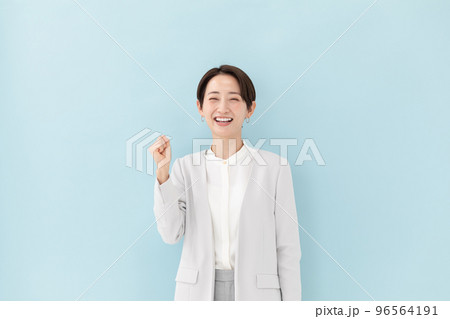 ビジネス　ガッツポーズ　女性　ブルーバック 96564191