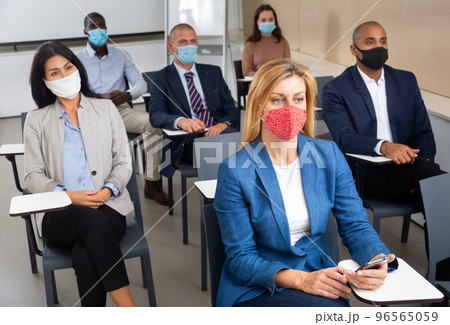 Young businesswoman in protective mask attending business seminar 96565059