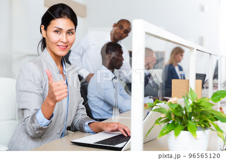 Portrait of successful business woman working at laptop in office 96565120