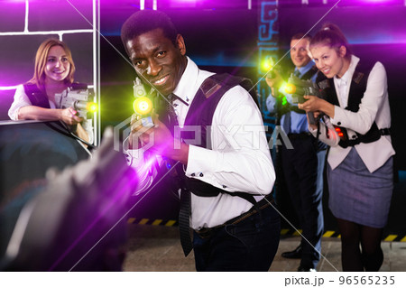 Afro businessman playing laser tag Afro businessman playing laser tag 96565235