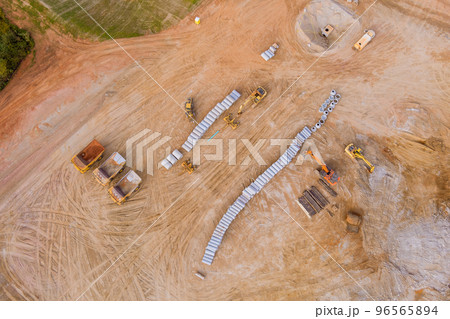 Panoramic aerial view of large construction site that is in use earthmoving equipment heavy machinery and tractors Panoramic aerial view of large construction site that is in use earthmoving equipment heavy machinery and tractors 96565894
