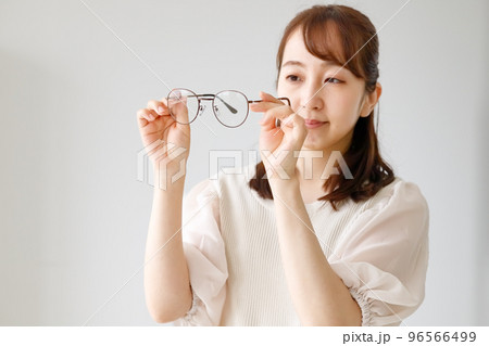 眼鏡のレンズやフレームの品質をチェックしている女性 96566499