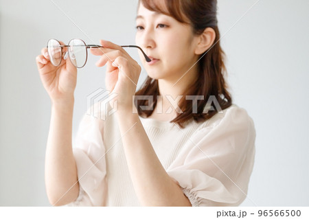 眼鏡のレンズやフレームの品質をチェックしている女性 96566500