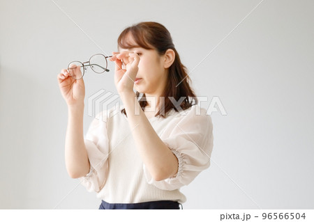 眼鏡のレンズやフレームの品質をチェックしている女性 96566504