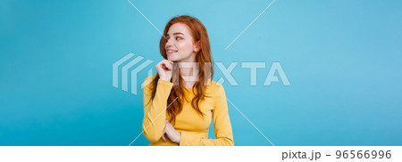 Portrait of happy ginger red hair girl with freckles smiling looking at camera. Pastel blue background. Copy Space Portrait of happy ginger red hair girl with freckles smiling looking at camera. Pastel blue background. Copy Space 96566996