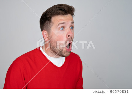 Shocked unshaven man expressing surprise on camera isolated over gray background 96570851