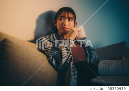 夕日を浴びながら読書をする若い女性の写真 夕日を浴びながら読書をする若い女性の写真 96570939