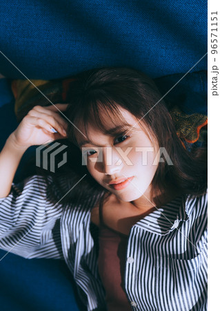 ソファーに寝転ぶ若い女性の写真 ソファーに寝転ぶ若い女性の写真 96571151