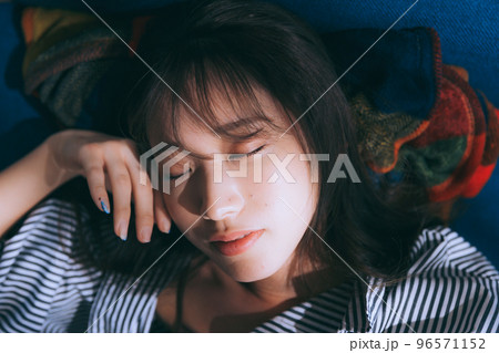 ソファーに寝転ぶ若い女性の写真 ソファーに寝転ぶ若い女性の写真 96571152