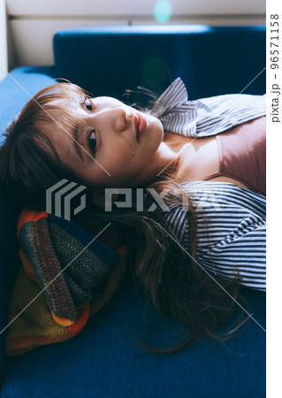 ソファーに寝転ぶ若い女性の写真 ソファーに寝転ぶ若い女性の写真 96571158