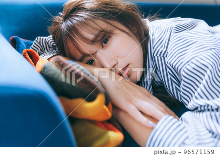 ソファーに寝転ぶ若い女性の写真 ソファーに寝転ぶ若い女性の写真 96571159