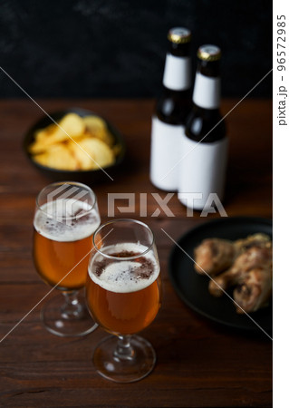 Two glasses with beer, snacks and bottles 96572985