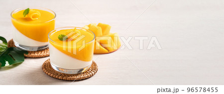 Delicious double colored mango panna cotta mousse pudding on wooden table background. 96578455