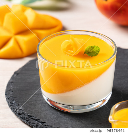 Delicious double colored mango panna cotta mousse pudding on wooden table background. Delicious double colored mango panna cotta mousse pudding on wooden table background. 96578461