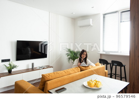 beautiful woman reading a magazine in the kitchen. apartment after renovation 96579546