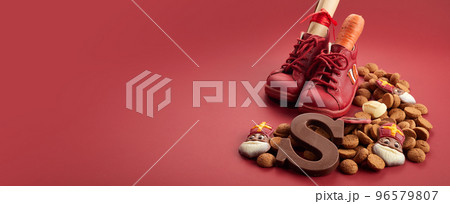 Saint Nicholas - Sinterklaas day with shoe, carrot and traditional sweets on red background Saint Nicholas - Sinterklaas day with shoe, carrot and traditional sweets on red background 96579807