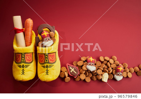 Saint Nicholas - Sinterklaas day with shoe, carrot and traditional sweets on red background 96579846