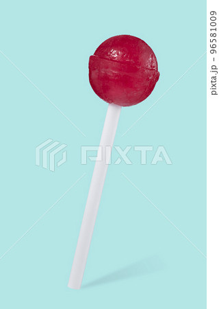Close-up of a red lollipop in the shape of a ball on a stick, isolated on a beautiful turquoise background with a shadow. Sweets. Close-up of a red lollipop in the shape of a ball on a stick, isolated on a beautiful turquoise background with a shadow. Sweets. 96581009