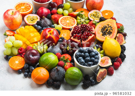 Circle made of healthy raw rainbow fruits, mango papaya strawberries oranges passion fruits berries on oval serving plate on light concrete background, selective focus 96581032
