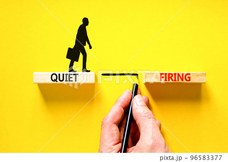 Quiet firing symbol. Concept words Quiet firing on wooden blocks. Beautiful yellow table yellow background. Businessman hand. Businessman icon. Business and quiet firing concept. Copy space. 96583377