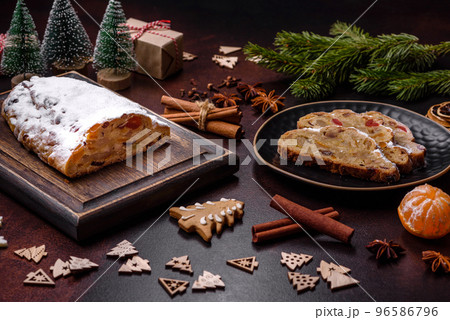 Christmas pie stollen with marzipan, berries and nuts on a dark concrete background Christmas pie stollen with marzipan, berries and nuts on a dark concrete background 96586796