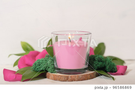 floral fragranced burning candle with green leaves, moss and petals. home fragrances, cozy home ambience, romantic decor for valentines.  96586869