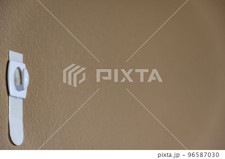 Selective focus on adhesive strip wall hanger that can be removed by pulling tape 96587030
