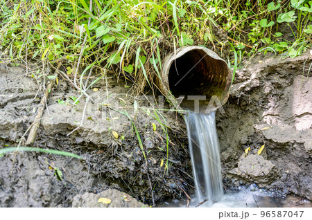 Water flowing from the open outlet of a metal agriculture drainage tile Water flowing from the open outlet of a metal agriculture drainage tile 96587047