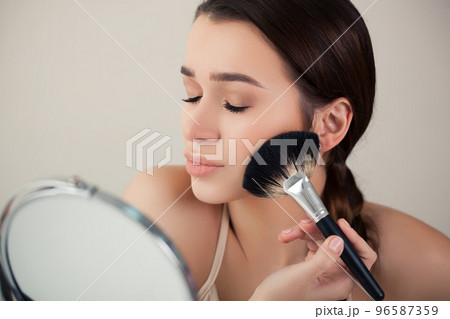 girl, woman in the mirror does makeup brush girl, woman in the mirror does makeup brush 96587359