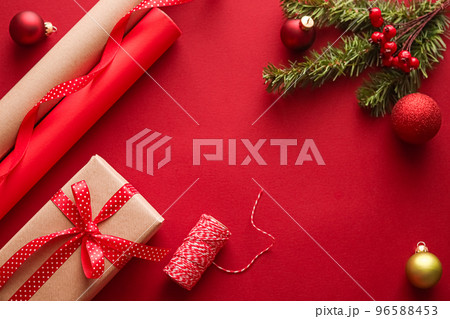 Christmas preparation, boxing day and holidays gift giving, xmas craft paper and ribbons for gifts boxes on red background as wrapping tools and decorations, diy presents as holiday flat lay design Christmas preparation, boxing day and holidays gift giving, xmas craft paper and ribbons for gifts boxes on red background as wrapping tools and decorations, diy presents as holiday flat lay design 96588453