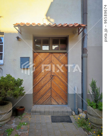 Old renovated wooden door entrance of a residential house with hanging post box on a wall on sunny day Old renovated wooden door entrance of a residential house with hanging post box on a wall on sunny day 96589674